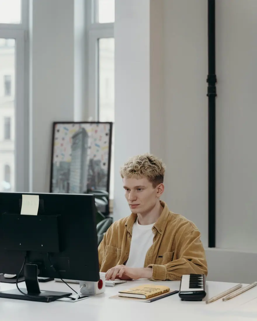 Estudiante joven haciendo prácticas profesionales en una empresa, trabajando con un ordenador